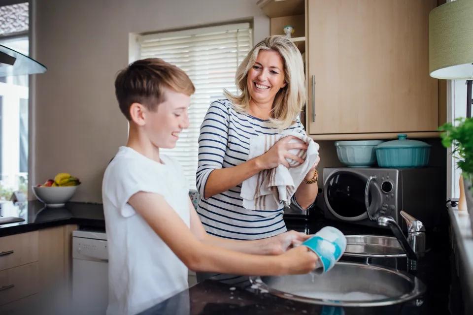 Support worker helping a participant with household chores in the kitchen